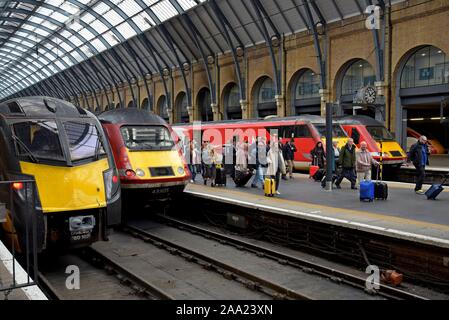 I passeggeri in partenza dei treni a Londra Kings Cross Station con LNER & Grand Central treni al terminus Foto Stock