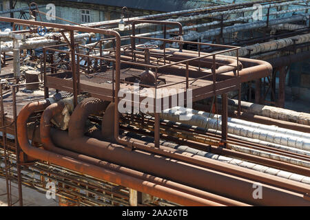 Vecchio arrugginito oleodotti in corrispondenza di un impianto chimico. Vecchia fabbrica. Fotografia industriale. Vecchia fabbrica fotografia orizzontale. Tavole metalliche e tubi. Foto Stock