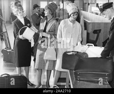 Il viaggio con la compagnia aerea negli anni sessanta. Due giovani donne vestite alla moda in modo puntuale degli anni sessanta abiti sono il controllo nei loro bagagli in aeroporto. La Svezia 1961 Foto Stock