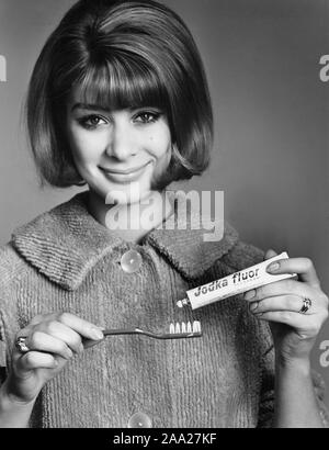 Donna negli anni sessanta. Ella è di mettere il dentifricio sul suo spazzolino da denti. La Svezia 1966 Foto Stock