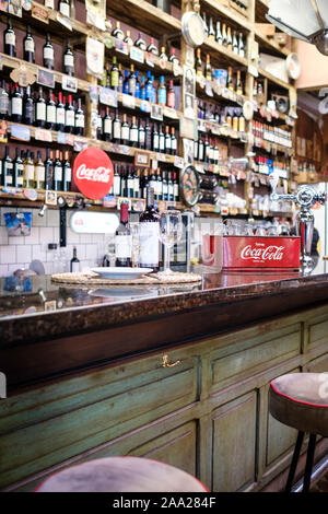 Le bottiglie e i bicchieri di vino rosso su un bancone bar in un ristorante classico a Salta Argentina Foto Stock