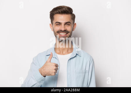 Close up ritratto con sorridente bello uomo barbuto Thumbs up. Foto Stock