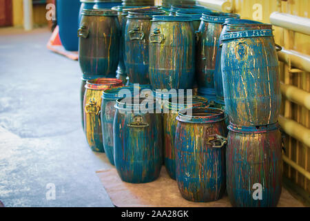 Barili di vernice presso la fabbrica di carta da parati. Contenitori di sporco con macchie di colorante. Foto Stock