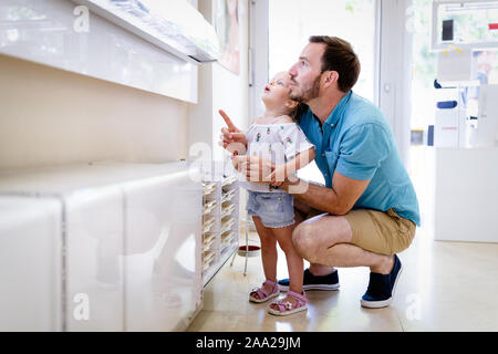 Bellissima bambina che sceglie i copybook nel negozio di cancelleria della  scuola, sorridendo vicino alla mamma mentre compra i rifornimenti  scolastici per la star Foto stock - Alamy