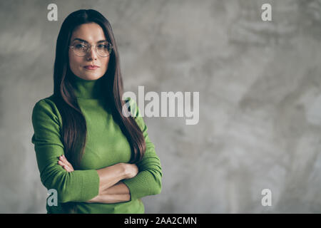 Foto di gravi fiducioso affascinante dai capelli lunghi donna con mani giunte fissando è sospettoso parete isolato di cemento grigio sfondo Foto Stock