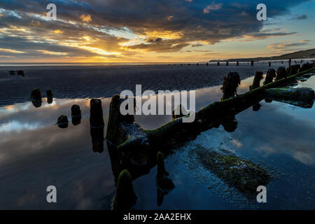 La mattina presto vista, con resti di pennelli, sulla spiaggia presso il villaggio sul mare di Sandsend, vicino a Whitby North Yorkshire England Regno Unito Foto Stock