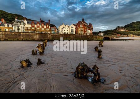 La mattina presto vista dalla spiaggia, con resti di pennelli, del villaggio sul mare di Sandsend, vicino a Whitby North Yorkshire England Regno Unito Foto Stock