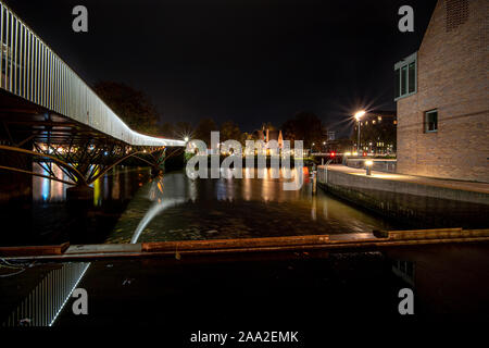 Illuminato il ponte di bicicletta nella notte lungo un vecchio porto in una città olandese Foto Stock