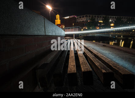 Vista su una banchina del porto nei pressi di un centro città con architettura moderna e linee in entrata che si riuniscono nel centro-oriented composizione del ph Foto Stock