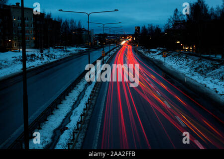 Umea, Norrland Svezia - 10 Novembre 2019: automobili lasciando una luce rossa sentieri di sera Foto Stock