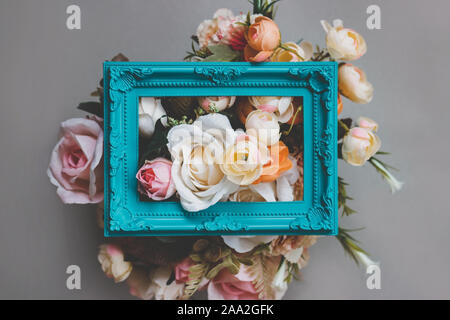 Composizione fatta di cornice e fiori artificiali in colori pastello Foto Stock