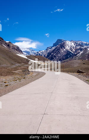 Alta strada di montagna al Parco Aconcagua con il Monte Aconcagua in background, provincia di Mendoza, Argentina Foto Stock