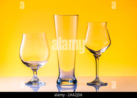 Impostare con tre diversi vuoto bicchieri da birra bianca su sfondo dorato. Concetto di alcool Foto Stock