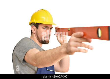 Allegro lavoratore edile - artigiano in abiti da lavoro con un livello di spirito su sfondo bianco Foto Stock