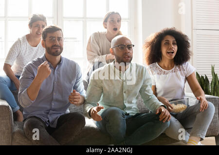 Giovani preoccupati migliori amici riuniti sul divano guardando la partita di calcio. Foto Stock
