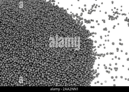 Pila di polistirene scuro beadlets nel retro bianco Foto Stock