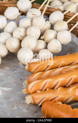 Thai street food: polpette di carne e salsicce sono la cottura a vapore sul vassoio in legno Foto Stock