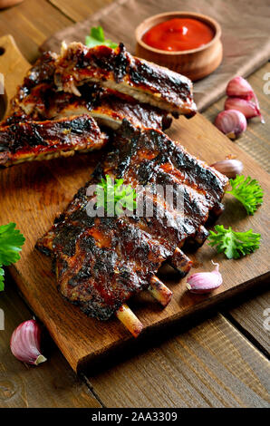 Grigliata di costolette di maiale sul tagliere. Gustosi barbecue di carne Foto Stock
