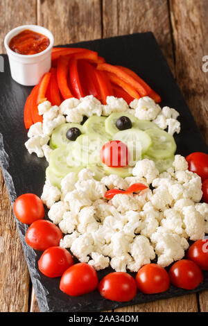 Natale snack vegetali in forma di Babbo Natale vicino sul piano verticale. Foto Stock