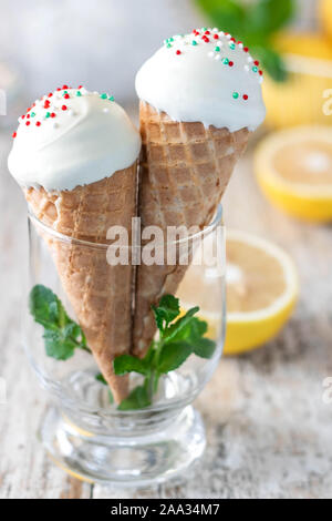 In casa di marshmallow di limone in un cono di cialda per il gelato alla crema di cioccolato bianco glassa. Dolci fatti in casa. Marshmallows in forma di gelato. Foto Stock