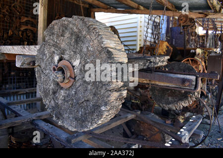 I resti di una vecchia ruota in legno su un assale situato su un vecchio carrello Foto Stock