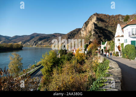 La gente a piedi lungo la strada di montagna per la parte moderna di Durnstein, accanto al fiume Danubio Foto Stock