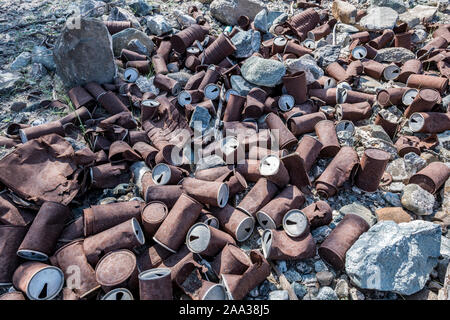 Lattine arrugginite disposte a terra, problema ambientale Foto Stock