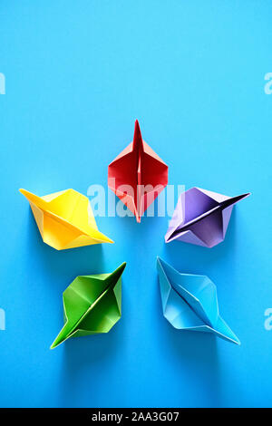 Origami autentiche barche in cerchio su sfondo blu Foto Stock