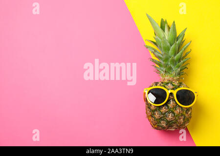 Ananas con occhiali da sole su due tonalità di sfondo, spazio per il testo Foto Stock