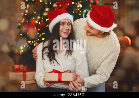 Amorevole marito dando la sua moglie regalo di Natale Foto Stock