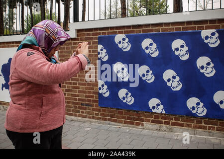 Tehran, Iran. Xix Nov, 2019. Un turista straniero prende una foto mentre cammina davanti ad una pittura murale lungo la parete della ex ambasciata degli Stati Uniti a Tehran, Iran. Tre il personale di sicurezza sono stati uccisi da ''rivoltosi'' in Iran, le ultime morti in proteste che non ha mostrato alcun segno di abbassandosi martedì nonostante un ondata di arresti e di internet di arresto. I decessi per almeno cinque il numero di persone che ha confermato di essere stato ucciso in Nationwide dimostrazioni che ha eruttato venerdì contro una scarica la decisione di imporre prezzi benzina escursioni. La situazione sulle strade rimane poco chiaro in gran parte a causa della Foto Stock