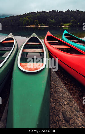 Canoe sul lungolago nella nebbia fredda mattina autunnale a Ribcev Laz, Slovenia Foto Stock