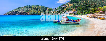 Turchese del mare,tradizionale barca da pesca e le montagne in Limnionas beach,isola di Samos,Grecia Foto Stock