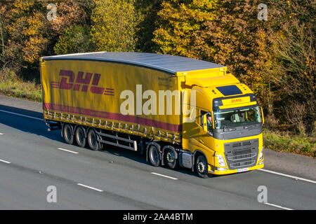 DHL spedizione internazionale; Giallo Haulage furgoni, camion, trasporto,Volvo Truck FH, cargo carrier, veicolo commerciale, trasporti, industria, M61 a Manchester, Regno Unito Foto Stock