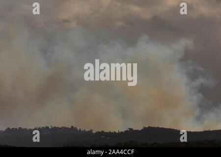 Fire Fighting elicotteri volare in fumo durante un incendio di bush nelle Blue Mountains in Australia Foto Stock