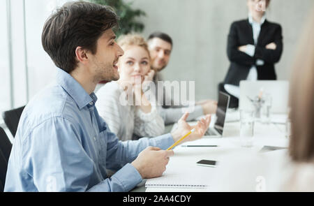 L'uomo la condivisione di idee creative con i colleghi alla riunione Foto Stock