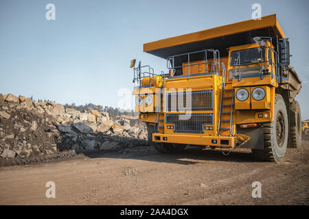 Grande giallo carrello minerario antracite con carico si sposta fossa aperta della miniera di carbone. Foto Stock