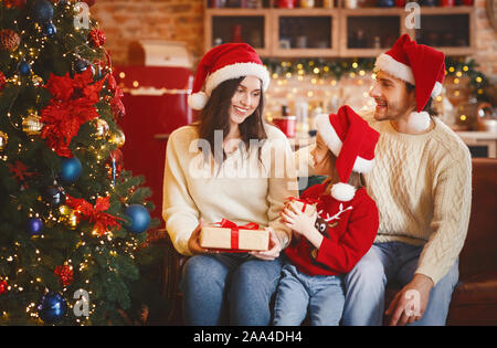 Madre e figlia lo scambio di regali di natale accanto a albero di Natale Foto Stock