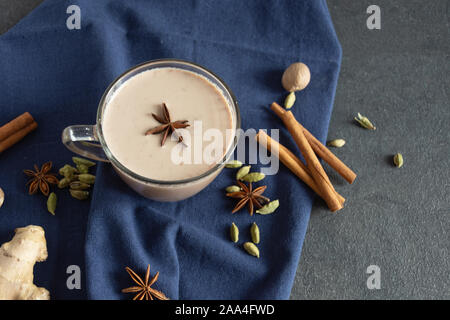 Masala chai realizzato dalla preparazione del tè nero con spezie aromatiche, come ad esempio la stecca di cannella, cardamomo tailandese, Zenzero, Anice Stellato, pepe nero e noce moscata. Glas Foto Stock