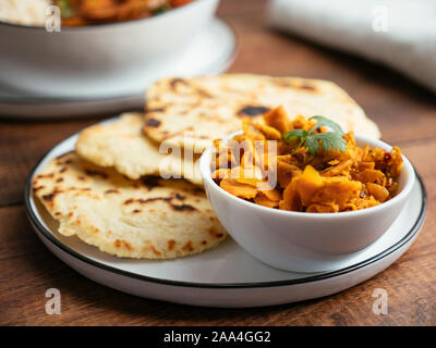 Il curry indiano, servita con fatti in casa pane naan e le carote e lo zenzero sottaceto. Foto Stock