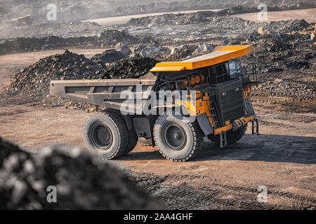 Grande giallo carrello minerario antracite con carico si sposta fossa aperta della miniera di carbone. Foto Stock