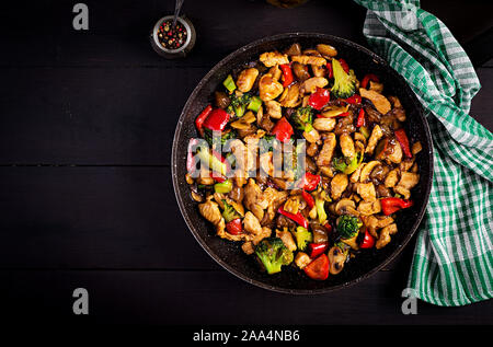 Stir fry con pollo e funghi, broccoli e peperoni. Cibo cinese. Vista superiore, overhead Foto Stock