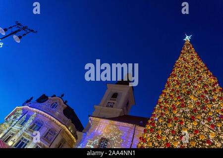 Mercatino di Natale a Sibiu in Transilvania. Inverno magico night immagine con i turisti e le decorazioni di Natale in Piazza Grande di città medievale Sibiu Foto Stock