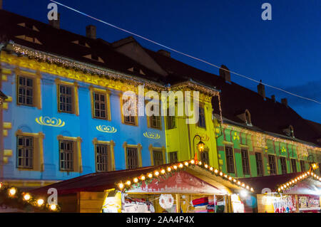 Mercatino di Natale a Sibiu in Transilvania. Inverno magico night immagine con i turisti e le decorazioni di Natale in Piazza Grande di città medievale Sibiu Foto Stock