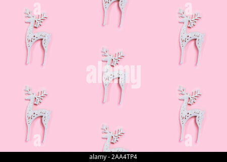 Modello realizzato di bianco Natale cervi decorazione sul rosa pastello sfondo. Foto Stock