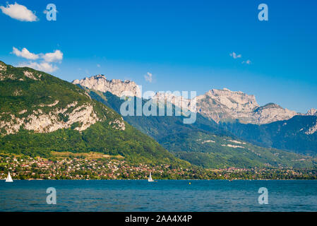 Una vista estiva del bellissimo lago di Annecy nelle Alpi francesi con le sue acque cristalline color turchese circondato da splendide montagne, Savoia, Francia. Foto Stock