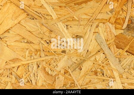 Materiale da costruzione. Pannelli OSB sono fatte di marrone da trucioli di legno levigato in uno sfondo di legno. Sfondo di fibra di legno di bordo. Foto Stock