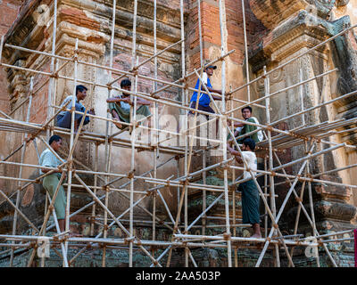 Lavoratori costruire il ponteggio necessaria per il ripristino della facciata di un antico tempio buddista nella zona archeologica di Bagan, Myanmar (Birmania). Foto Stock