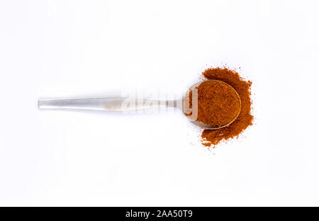 Peperoncino rosso in polvere in cucchiaio di metallo su sfondo bianco. Vista da sopra con copia spazio per il testo. Foto Stock