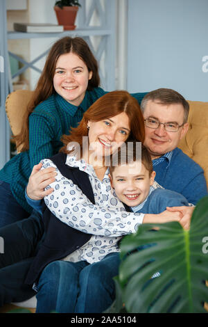 Sessione fotografica - famiglia amichevole. Ritratto di famiglia di quattro sorrisi Foto Stock